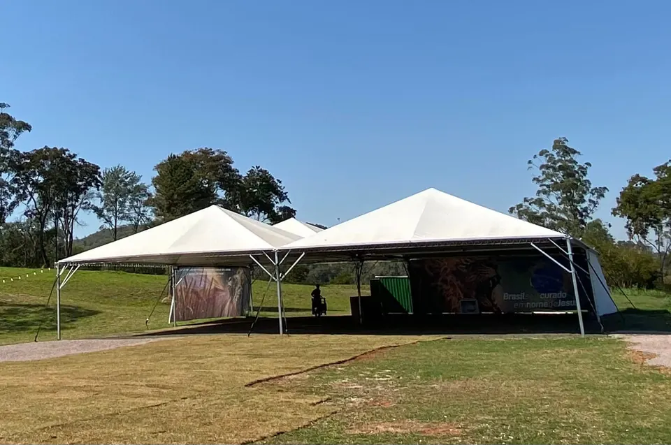 Pessoas reunidas sob a tenda do espaço de demonstração do Hub 5x7